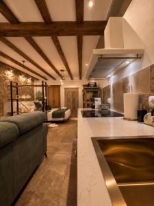 a kitchen and living room with a couch and a table at Al Zahra Suites in Zahara de la Sierra