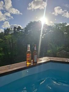 two bottles of beer sitting on the edge of a swimming pool at Évasion Caraïbes in Ducos