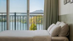 a hotel room with a bed and a large window at Chuncheon Rehouse in Chuncheon