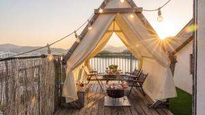 a tent on a deck with a table and a grill at Chuncheon Rehouse in Chuncheon