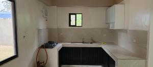 a small kitchen with a sink and a window at Melinda place in Camarin