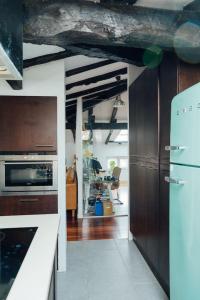 a kitchen with wooden cabinets and a refrigerator at GOZATEGI - Photo studio in Irún