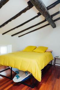 a bed with yellow sheets and pillows in a room at GOZATEGI - Photo studio in Irún