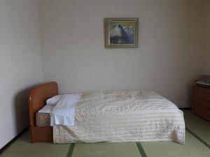 a bed in a bedroom with a picture on the wall at Ebeotsu Onsen in Takikawa