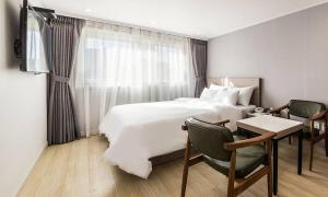 a hotel room with a bed and a desk and chair at Anyang ILLOWA Hotel in Anyang