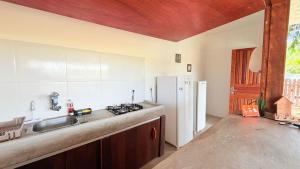a kitchen with a sink and a refrigerator at Chalé Begê in Barra Grande