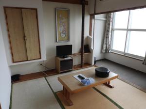 a living room with a coffee table and a tv at Ebeotsu Onsen in Takikawa