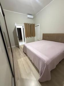 a bedroom with a white bed in a room at casa da piscina e churrasco in Maringá +46 photos