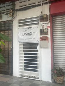 a garage door with a sign on the side of a building at Sejiwo Apartment 6-8pax in Pengkalan Cepa