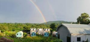 a rainbow over a group of buildings with a house at Farm Terrace in Kaengsopha