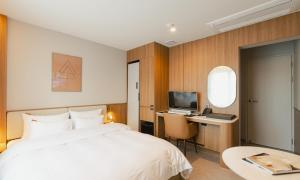 a bedroom with a bed and a desk with a computer at Brown Dot Hotel Andong Taehwa in Andong +85 photos