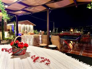 a table with a basket of red flowers on it at Tuscany Villa Jarash in Al Madwar