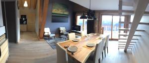 a dining room with a wooden table and chairs at Chalet Skiopied in La Toussuire