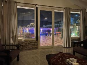 a room with large windows with a view of a patio at Tuscany Villa Jarash in Al Madwar +38 photos