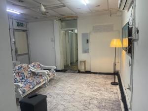 a living room with a couch and a lamp at Sejiwo Apartment 6-8pax in Pengkalan Cepa
