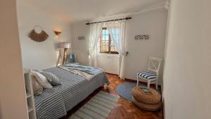a small bedroom with a bed and a window at Casa dos Rebolinhos in Sagres