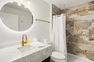 a bathroom with a sink and a mirror at Downtown Omaha - Elevated Studio & 1-Bed Stays in Omaha +18 photos