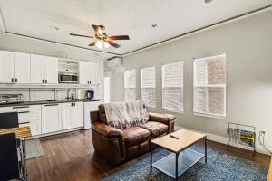 a living room with a couch and a ceiling fan at Downtown Omaha - Elevated Studio & 1-Bed Stays in Omaha