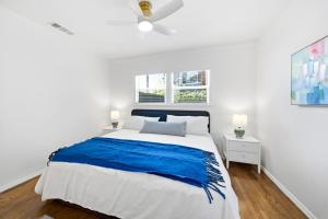 a white bedroom with a large bed and two windows at Venice Venice in Los Angeles