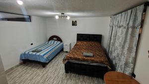 a small bedroom with a bed and a table at Departamento Confortable in Latacunga