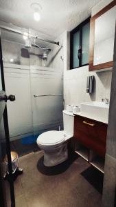 a bathroom with a toilet and a sink at Departamento Confortable in Latacunga