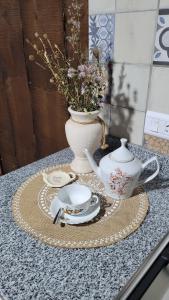 a table with a tea set and a vase at Namasté in Villa Larca