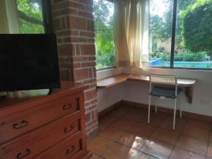 a room with a desk and a chair and a television at Rincón de la Luna in Tepoztlán