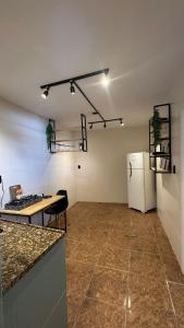 a kitchen with a table and a refrigerator in a room at Apartamento em Petrópolis 1 quarto completo in Petrópolis