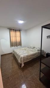 a bedroom with a bed in a room with a window at Apartamento em Petrópolis 1 quarto completo in Petrópolis