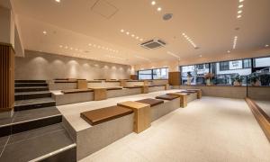 a waiting area of a restaurant with benches and tables at Masan Daisy Hotel in Changwon