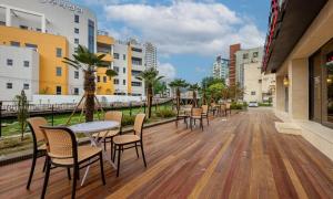 a wooden deck with chairs and tables on a city street at Masan Daisy Hotel in Changwon