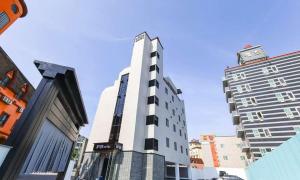 a tall white building in the middle of a city at JECHEON No 25 HOTEL in Jecheon