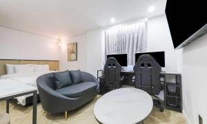 a hotel room with a bed and a desk and chairs at JECHEON No 25 HOTEL in Jecheon