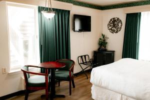 a bedroom with a bed and a table and chairs at Emerald Dolphin Inn & Mini Golf in Fort Bragg