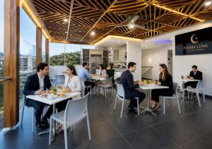 a group of people sitting at tables in a restaurant at Piedra Luna in Cali