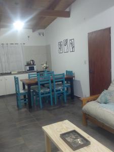 a living room with a table and blue chairs at Quinta Los Sauces in Nueve de Julio