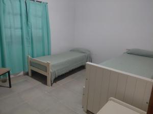 a bedroom with two beds and a bench in it at Quinta Los Sauces in Nueve de Julio
