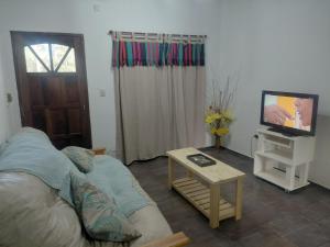 a living room with a couch and a tv at Quinta Los Sauces in Nueve de Julio +5 photos