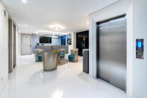 a lobby with a silver elevator and a table and chairs at Piedra Luna in Cali