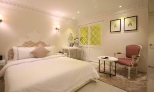 a bedroom with a bed and a table and a chair at Jeonju Mari Hotel in Jeonju