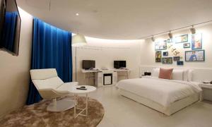 a bedroom with a bed and a chair and a table at Jeonju Mari Hotel in Jeonju
