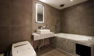 a bathroom with a toilet and a sink and a tub at Jeonju Mari Hotel in Jeonju