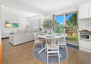 a kitchen and living room with a table and chairs at Flinders Hideaway in Shellharbour +24 photos