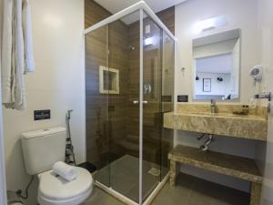 a bathroom with a shower and a toilet and a sink at Augusta Centro Hotel in Canela +81 photos