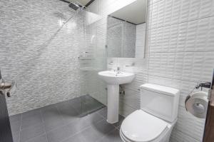 a white bathroom with a toilet and a sink at Dangjin Hotel IVAN in Dangjin