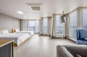 a bedroom with two beds and a view of the ocean at Dangjin Hotel IVAN in Dangjin
