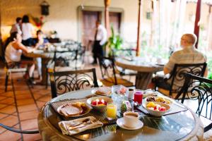 a table with breakfast food on it in a restaurant at Los Robles Charming Colonial Boutique Hotel in Managua