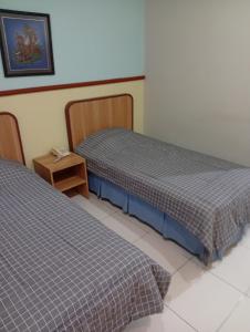 two beds sitting next to each other in a room at Carica homestay in Surabaya