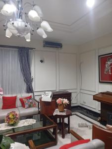 a living room with a couch and a piano at Carica homestay in Surabaya