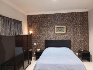 a bedroom with a bed and a wall at Carica homestay in Surabaya